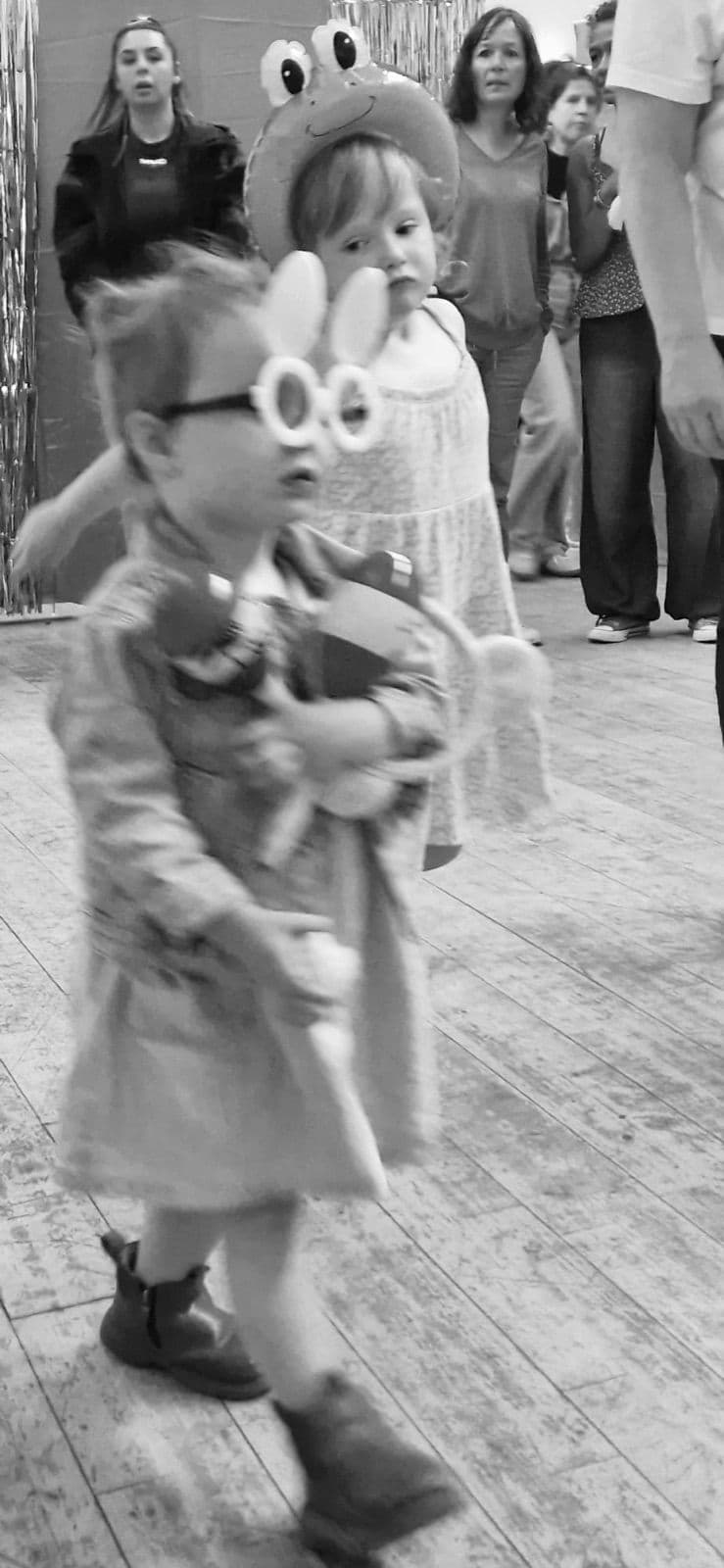 Families in fancy dress and costumes, in black and white.