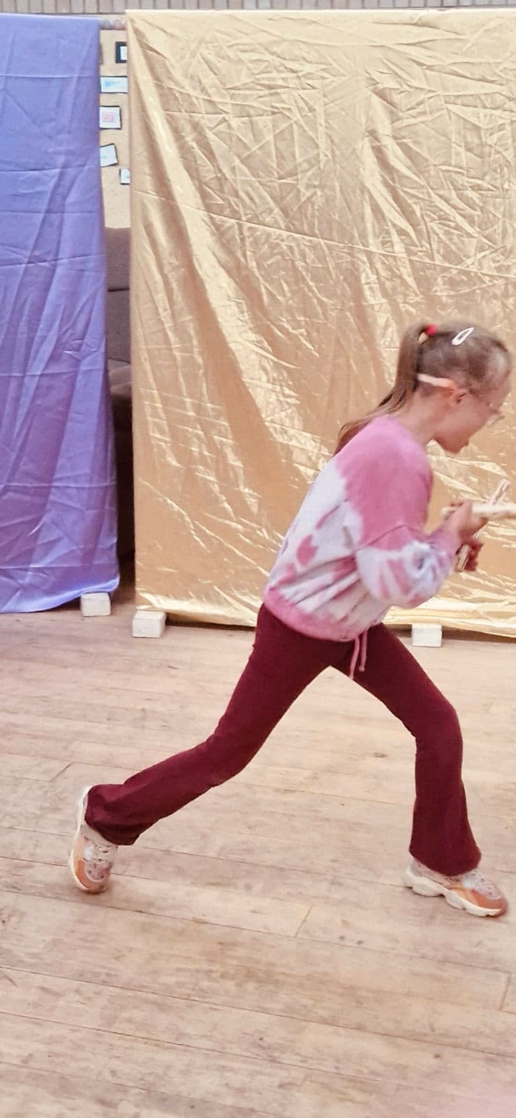 Dancing in front of a shimmering gold backdrop.