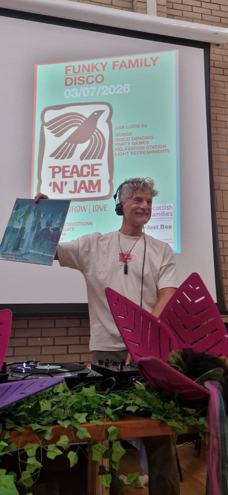 Dominic behind the decks, holding up a favourite record.